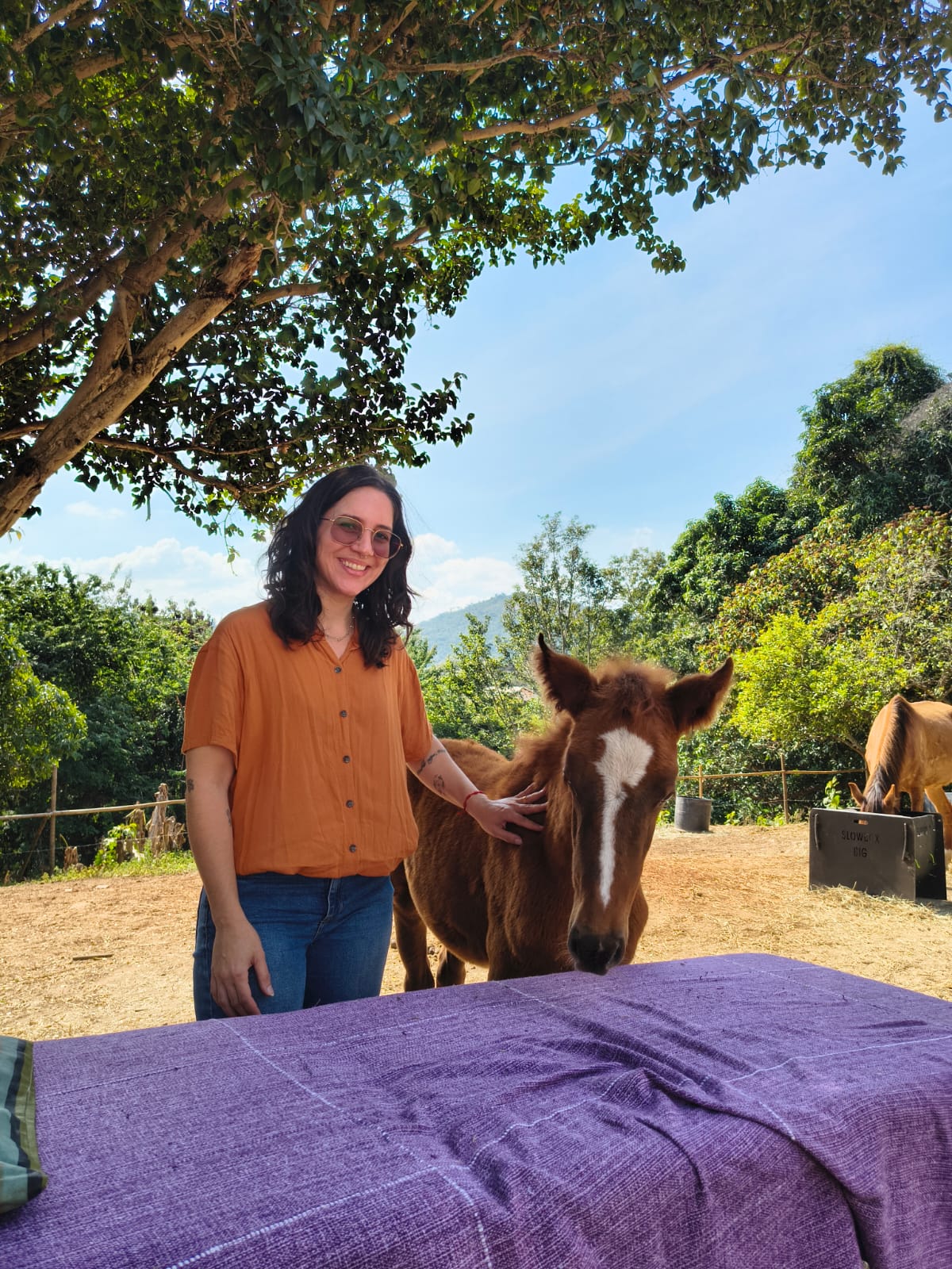 Ursola Sabino ao lado de um cavalo, ao ar livre